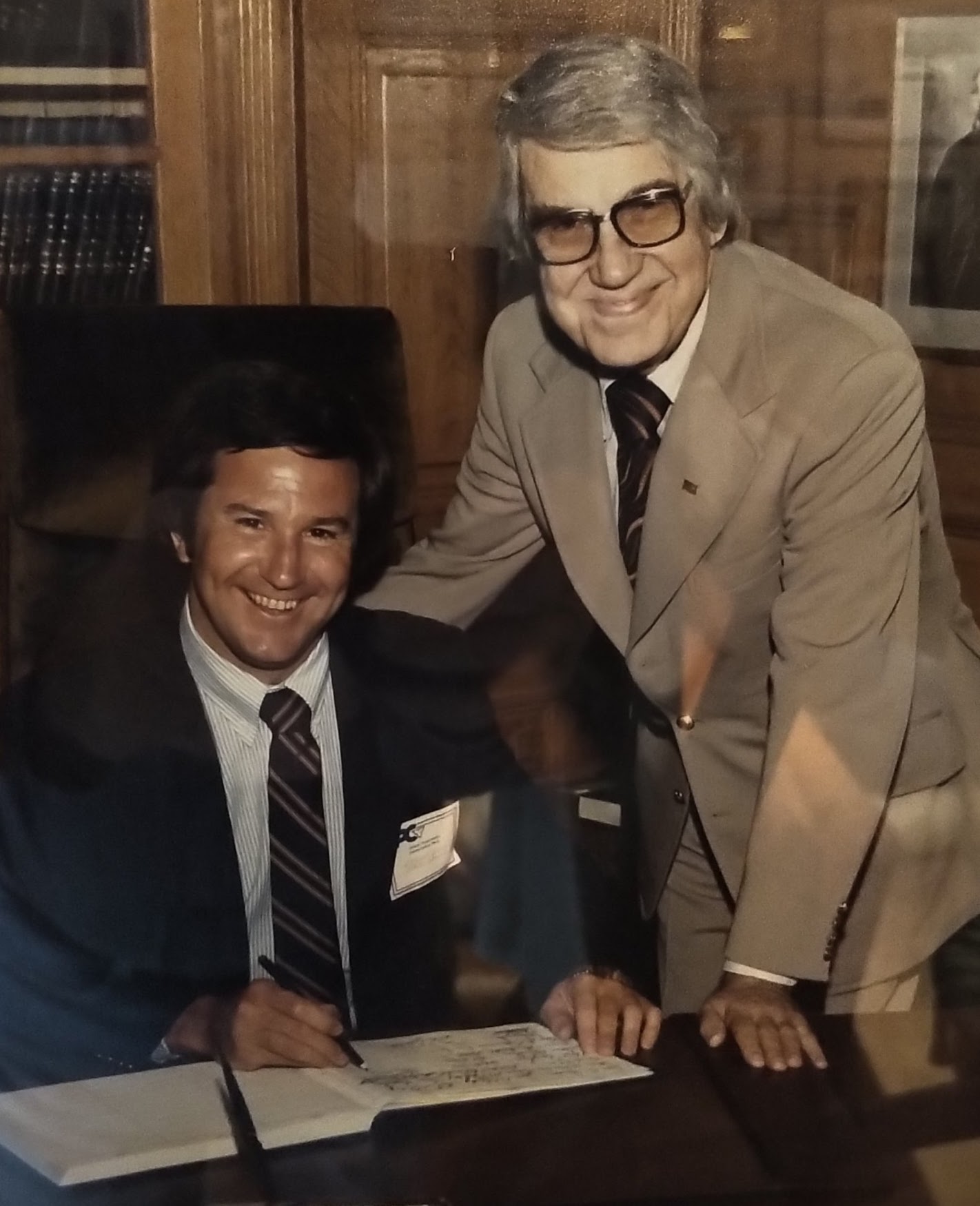two men sit at a desk