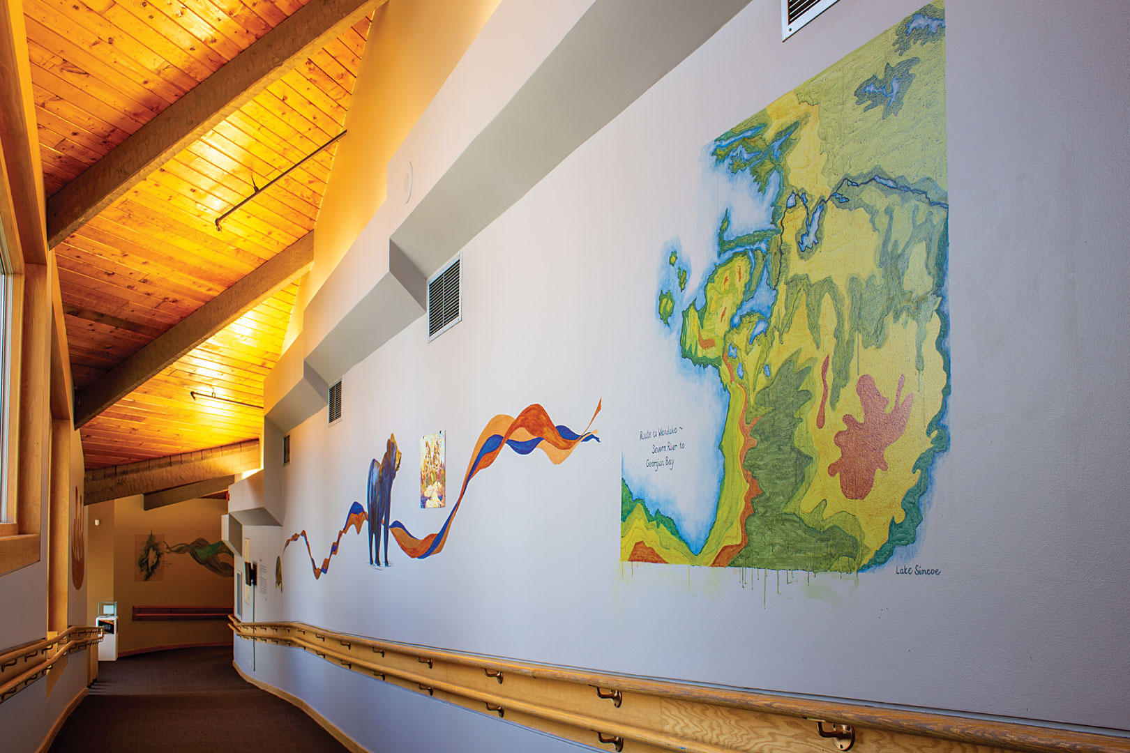 A colourful mural featuring a map of Georgian Bay painted on a hallway wall