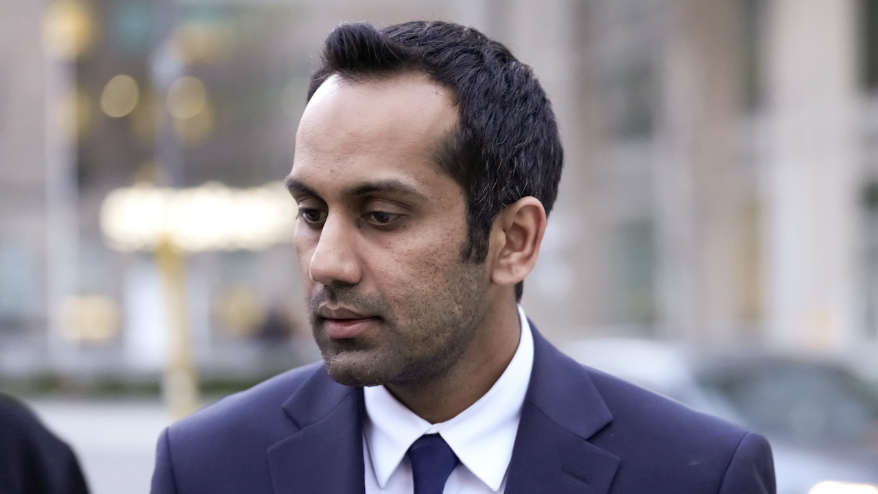 closeup of suited man with blurred city street in background