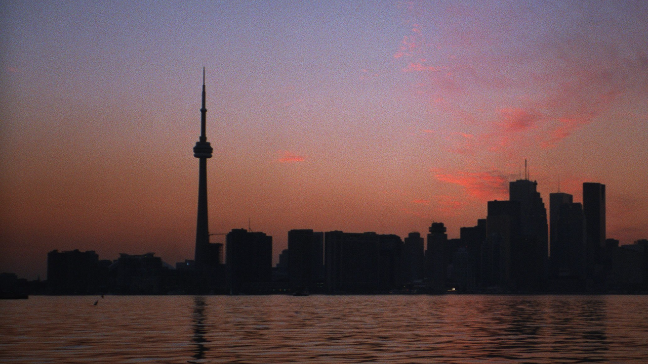dark, pinkish sky with totally unilluminated Toronto skyline